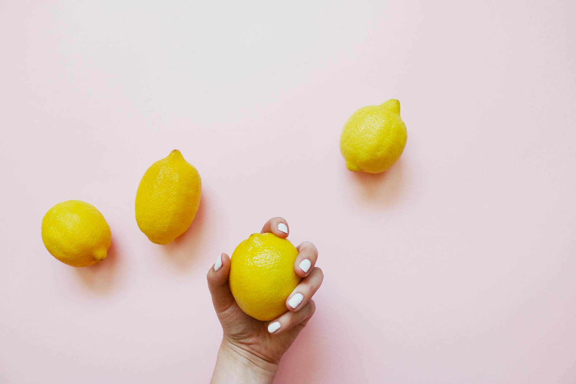 Bright yellow lemons on a pastel green background, symbolizing freshness and renewed vitality in intimate relationships