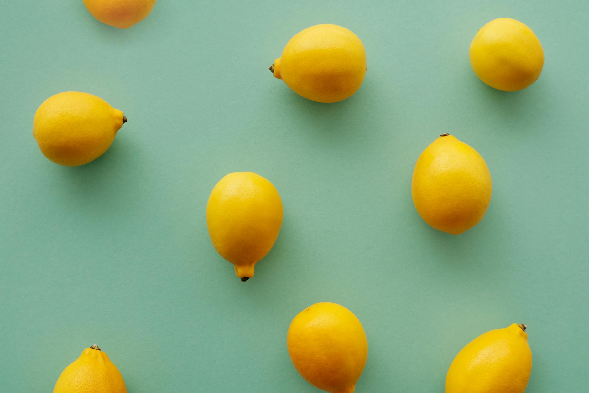 Bright yellow lemons arranged on a pastel green background, symbolizing renewal and fresh starts