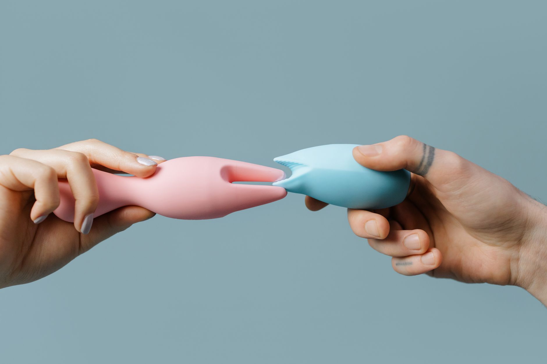 Hand holding an orange vibrator against a purple backdrop, symbolizing reclaiming pleasure during depression